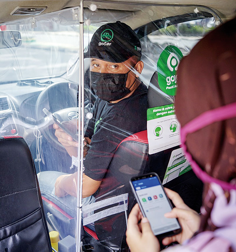 Armada GoCar telah meÂ­lengÂ­kapi protokol kesehatan dengan menyediakan fasilitas sekat pelindung di mobilnya untuk membatasi pengemudi dan penumpang, baru-baru  ini.(GOJEK FOR RIAUPOS.CO)