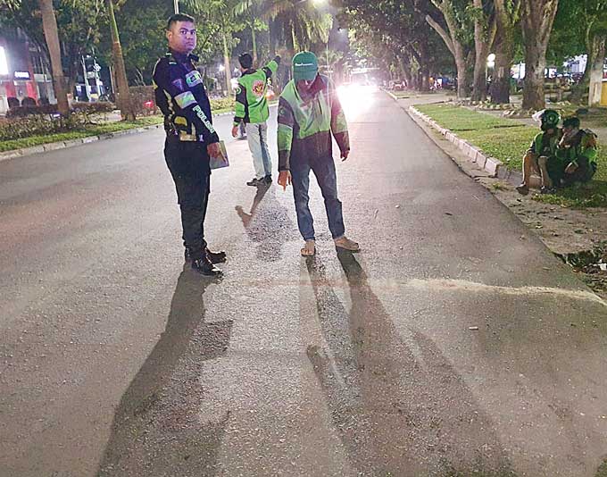 Personel Satlantas Polresta Pekanbaru dan beberapa driver ojol menunjukkan tempat kejadian perkara kecelakaan lalu lintas yang merenggut nyawa pengendara ojol, Senin (27/3/2023) malam.