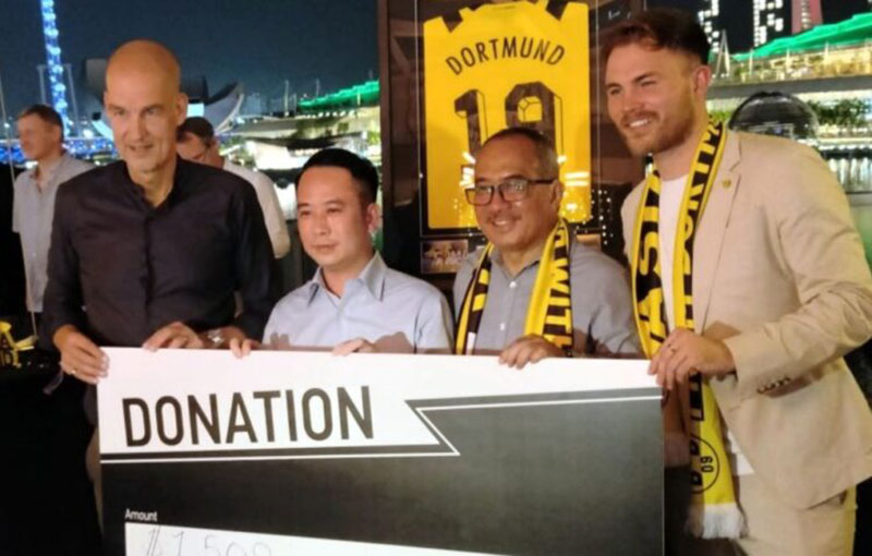 Managing Director Dortmund, Carsten Cramer menyerahkan hasil lelang Julian Brandt kepada Duta Besar Indonesia untuk Singapura, Suryopratomo di One Fullerton Hotel, Singapura, Rabu (23/11/2022).