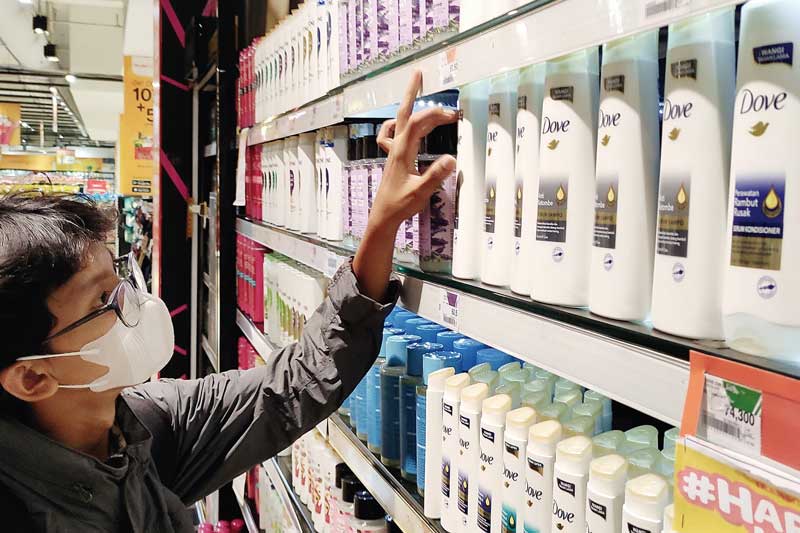 Pengunjung melihat produk perawatan rambut di salah satu ritel modern di Surabaya,  beberapa waktu lalu. Aprindo menyebut volume transaksi ritel belum terdampak dengan suasana di global.