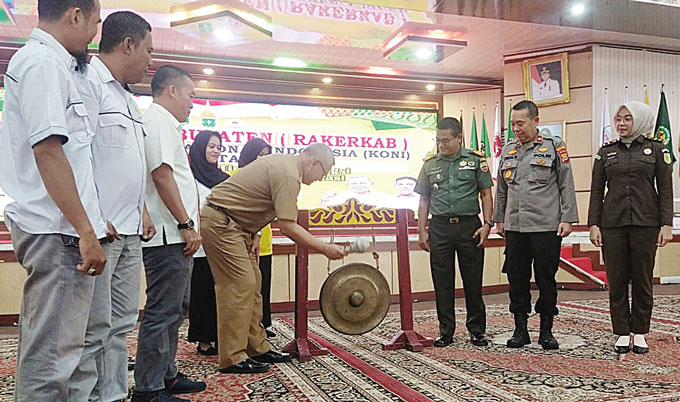 Asisten I Setdakab Rohil Drs Ferry H Parya memukul gong tanda dimulainya kegiatan Rakerkab KONI Rohil di Bagansiapiapi, Senin (29/5/2023).