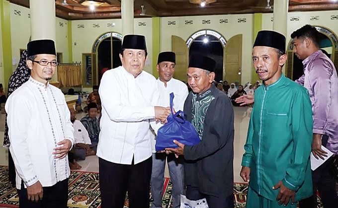 Bupati Rohul H Sukiman menyerah bantuan paket sembako kepada perwakilan warga saat kunjungan Safari Ramadan Pemkab Rohul di Masjid Al Muhajirin, Desa Pasir Utama, Kecamatan Rambah Hilir, Senin (10/4/2023) malam.