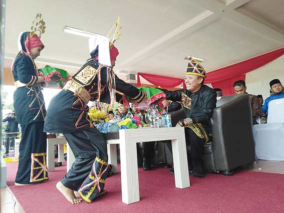 SIRIH: Salah seorang penari memberikan sirih kepada Kapolres Kuansing AKBP Fibri Karpiananto SH SIK saat pembukaan Pacu Jalur di Lapangan Limuno, Rabu (29/8/2018).