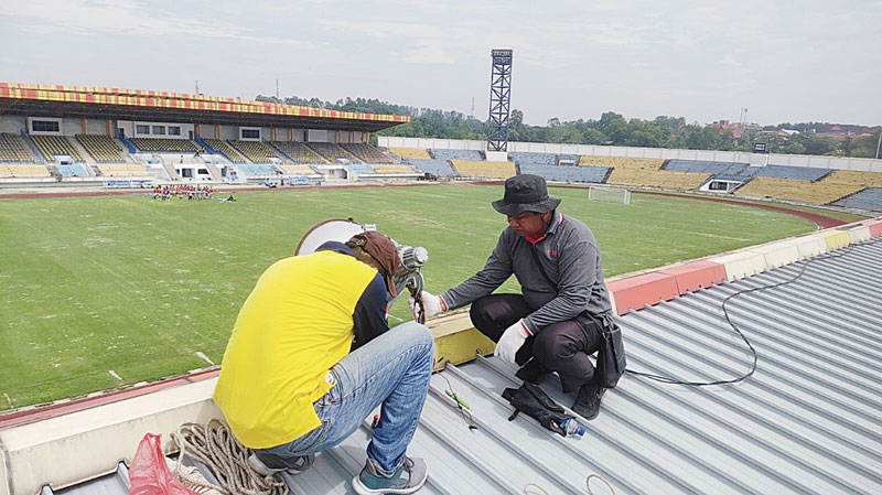 Pekerja memasang lampu di atap tribun untuk menambah pencahayaan Stadion Kaharuddin Nasution, Rumbai, pekan lalu.