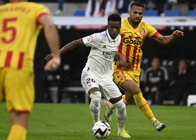 Gelandang Girona Yangel Herrera (kanan) berusaha merebut bola dari pemain Real Madrid Vinicius Junior dalam pertandingan Liga Spanyol di Santiago Bernabeu, Senin (31/10/2022) dini hari WIB.
