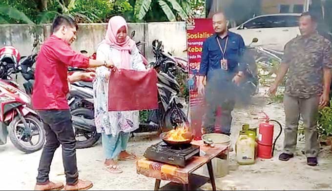 Salah seorang ibu mempraktikkan cara memadamkan api di dapur, Sabtu (1/4/2023).