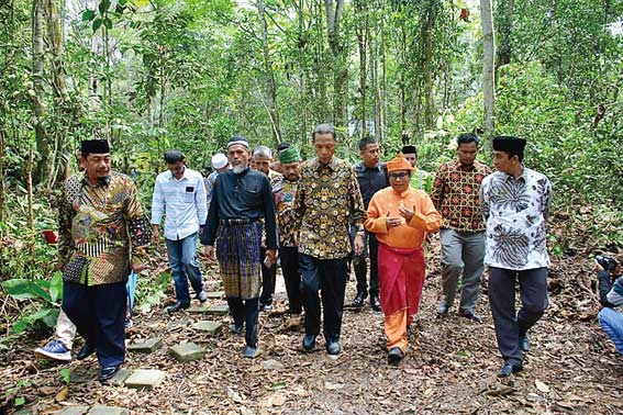 MENYUSURI HUTAN: Bupati Kampar Azis Zaenal (tengah) bersama Kepala DLH Kampar Cokroaminoto (paling kiri) menyusuri Imbo Putuih atau hutan adat di Petapahan, Kabupaten Kampar. Foto diambil beberapa waktu lalu.