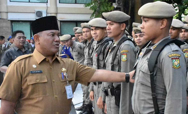 CEK KEHADIRAN: Sekda Kampar Yusri (kiri) melakukan cek kehadiran pegawai setelah apel pada hari perdana masuk kerja di Kantor Bupati Kampar, Senin (10/6/2019).