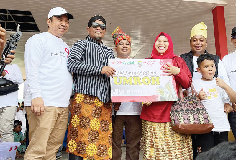 Eni Sumarni menerima hadiah tiket umrah gratis usai mengikuti kegiatan Jalan Sehat Helat Pelalawan, Ahad (8/10/2023).