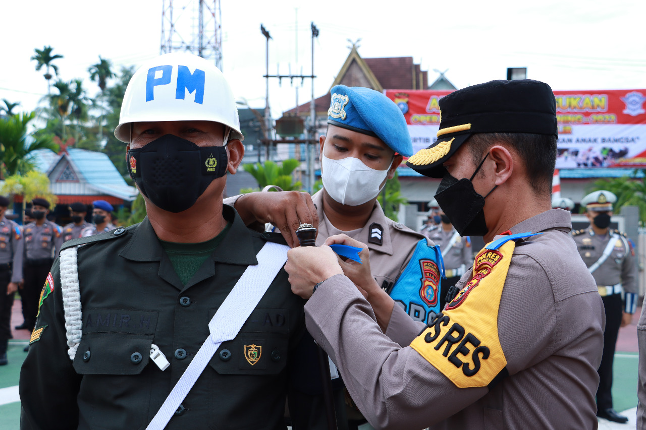 Kapolres Inhil AKBP Dian Setyawan, mengenakan tanda operasi Lancang Kuning 2022, kepada perwakilan pasukan yang terlibat dalam operasi ini, Senin (13/6/2022).