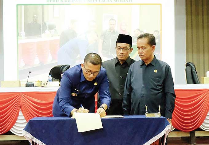 Ketua DPRD Kepulauan Meranti, Fauzi (berpeci) dan Wakil DPRD M Khalid mendampingi Bupati H Muhammad Adil menandatangani naskah pengesahan perda PT Bumi Meranti, Rabu (19/10/2022) malam.