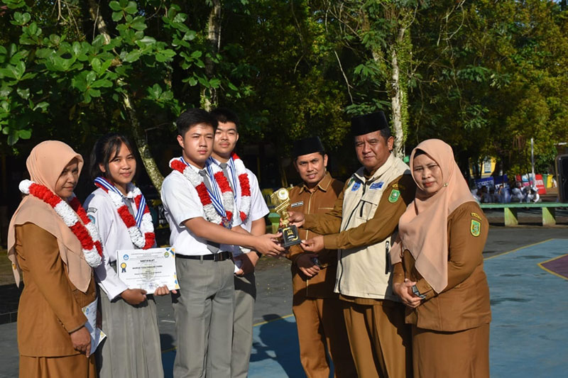 Kepala SMAN 1 Telukkuantan, Saprianto Eldi SPdI memberikan piala kepada pemenang lomba di Telukkuantan, Jumat (20/1/2023).