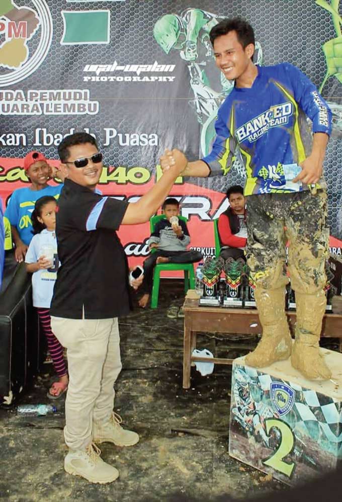 Fedrios Gusni saat memberikan ucapan selamat kepada salah seorang pemenang motor cross, baru-baru ini.
