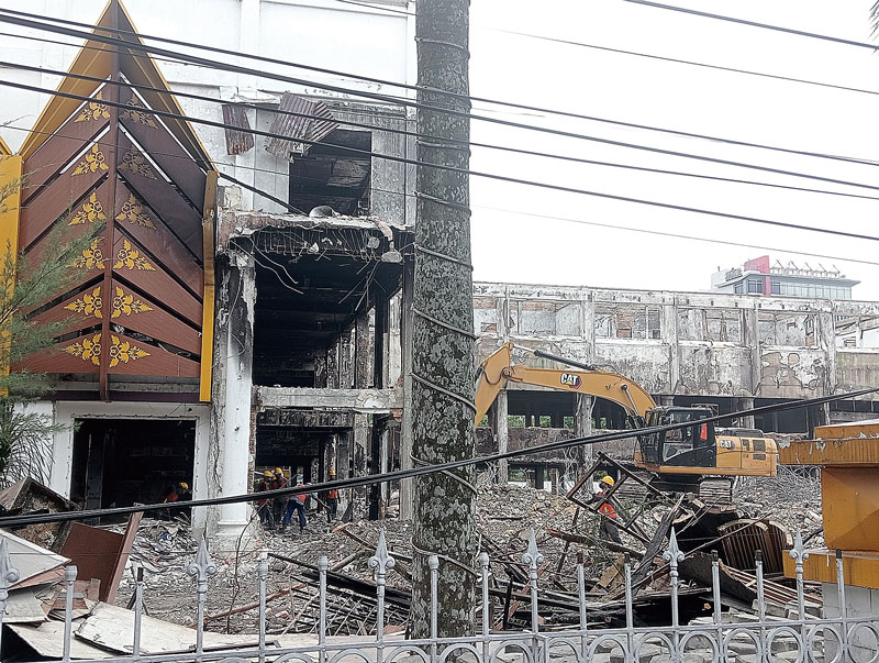 Dibantu satu unit alat berat, para pekerja merobohkan gedung utama MPP Pekanbaru, Senin (9/10/2023).