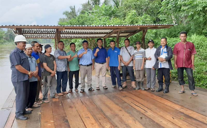 TEKS FOTO: Mill Manager Edy Gunawan didampingi Humas PT Indomakmur Sawit Berjaya Malinton H Purba SH foto bersama dengan Kepala Dusun Surau tinggi Selatan Desa Rambah Yunus dan masayrakat, usai penyerahan bantuan Getek sebagai alat transportasi penyeberan