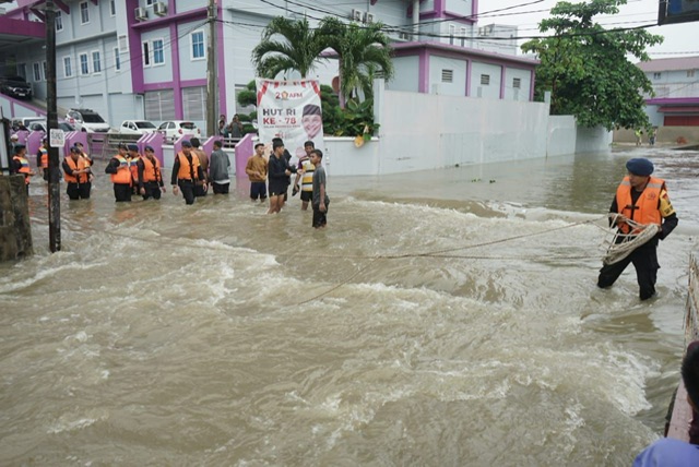 Satbrimob Polda Riau memasang tali pengaman di arus kuat saat banjir melanda Kota Pekanbaru, seperti di Jalan Puyuhmas, pada Rabu (6/9/2023).