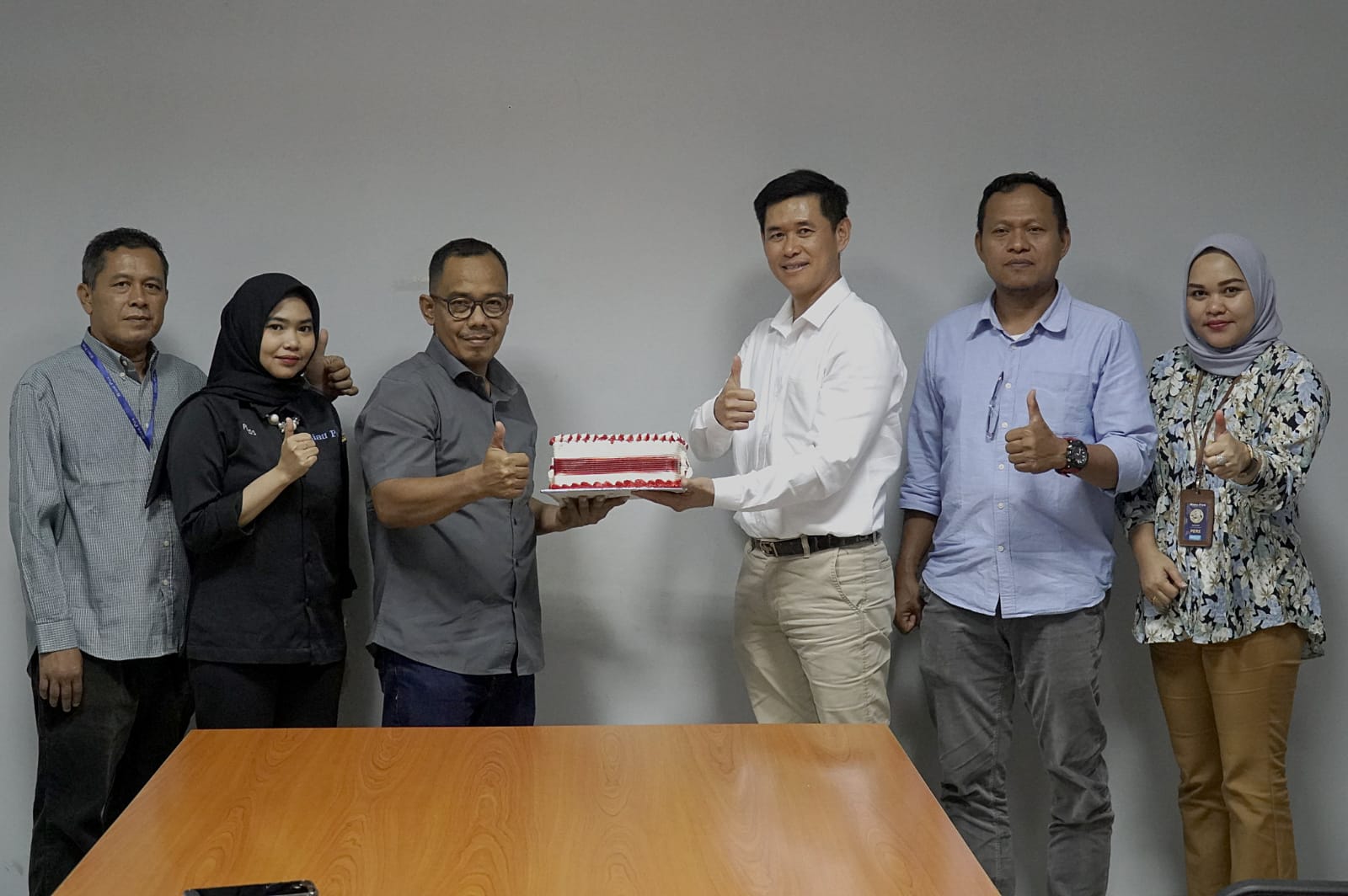 Direktur Riau Pos Asmawi Ibrahim (tiga kiri) didampingi Manajer Iklan Riau Pos Sumariono (lima kiri), Tim Iklan Riau Pos Dewi (kanan), Edison (kiri), Asisten Redaktur Riau Pos Siti Azura (dua kiri), memberikan kue Ulang Tahun ke-36 PT Alfa Scorpii kepada