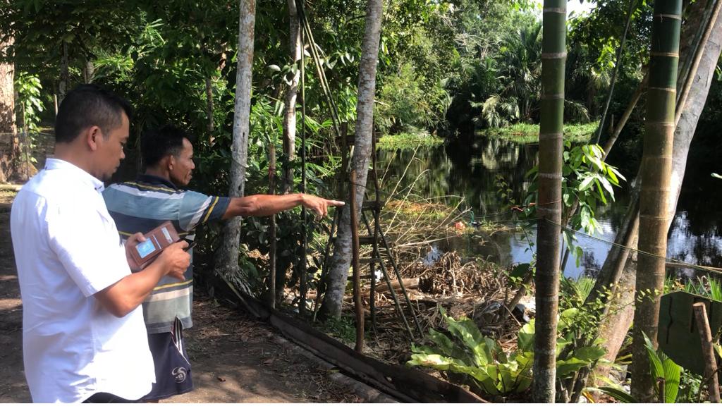 Salah seorang warga yang tinggal di tepian Sungai Mempura, Ujang yang berdiri di Samping Kasi Pemerintahan Kelurahan Sungai Mempura Afri Chandra menunjuk ke Sungai Mempura, di mana muncul buaya muara berukuran 3 meter saat air sedang surut, Rabu (15/11/20
