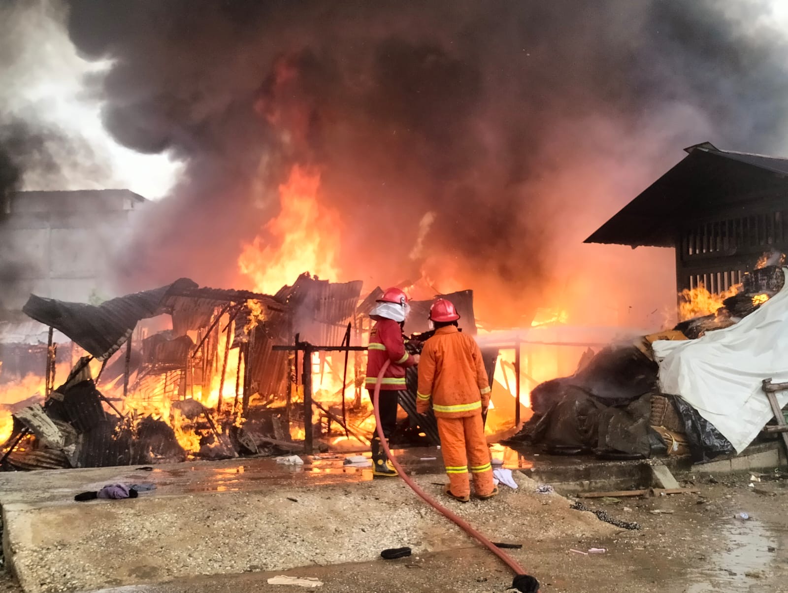 Petugas Damkar Dumai melakukan upaya pemadaman api yang menghanguskan 25 petak rumah yang yang berada di Jalan Budi Kemuliaan, Kota Dumai, Selasa (12/12/2023).