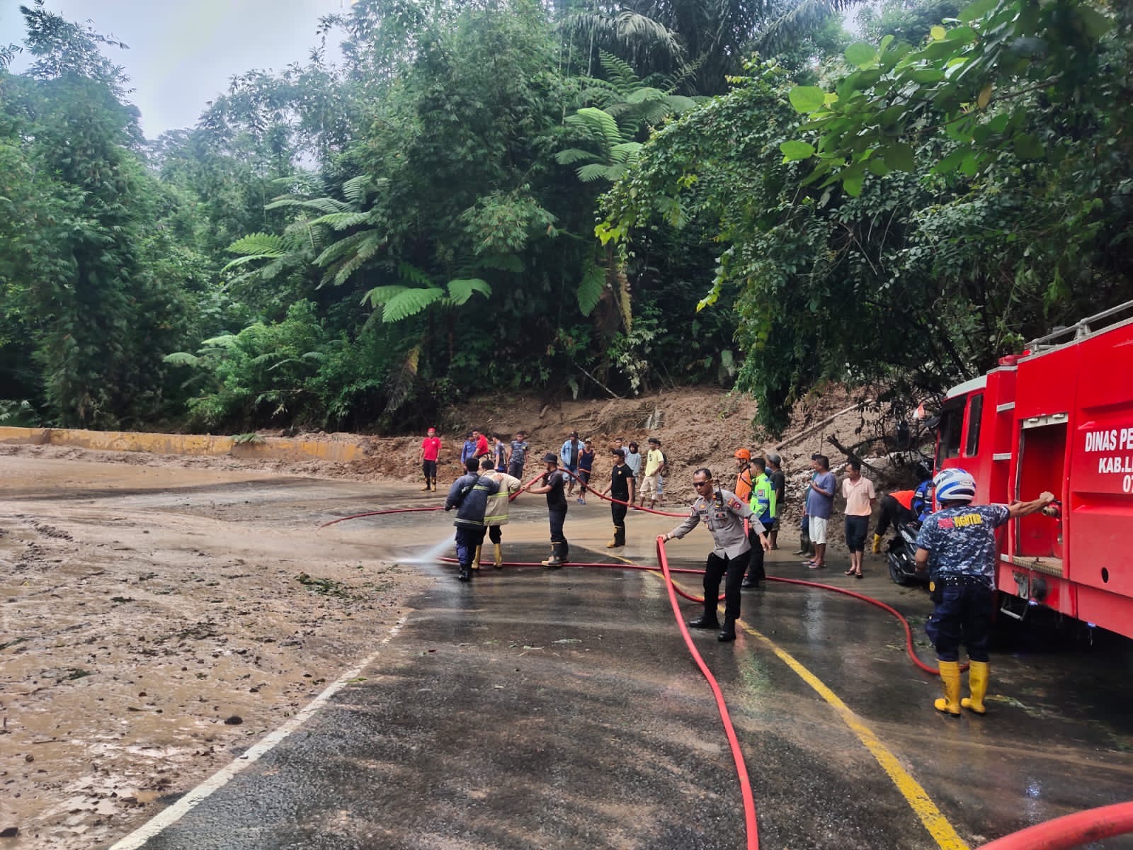 Material tanah dan bebatuan longsor telah dibersihkan dan kini ruas jalan penghubung utama Riau-Sumbar terdampak longsor di Jorong Ulu Aia Nagari Harau, Kecamatan Harau, Limapuluh Kota, sudah bisa dilewati kendaraan, Senin (18/12/2023) siang,
