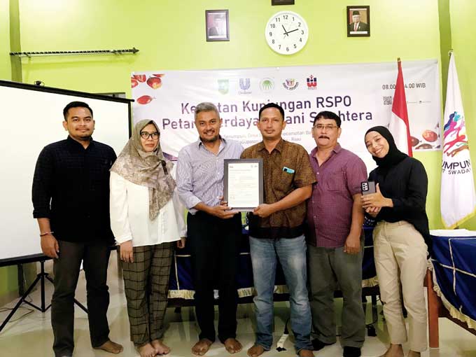 Head of Smallholders Programme RSPO Guntur Cahyo Prabowo (tiga kiri) menyerahkan sertifikat RSPO secara simbolis kepada perkumpulan petani sawit swadaya Karya Serumpun, Juliono didampingi pengurus lainnya, Sabtu (14/1/2023).