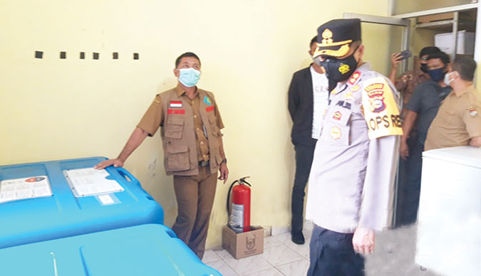 Kapolres Kampar AKBP Mohammad Kholid didampingi Kepala Dinas Kesehatan Kampar Dedy Sambudi, meninjau ruang penyimpanan vaksin Sinovac di UPT Farmasi dan Logistik Diskes Kampar, Senin (11/1/2021). (HENDRAWAN KARIMAN/RIAUPOS.CO)
