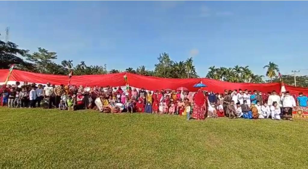 Warga Dusun Jatimulya, Kampung Jatibaru, Kecamatan Bungaraya, Siak berswafoto di depan bentangan bendera sepanjang 45 meter, usai upacara pada Selasa (17/8/2021).