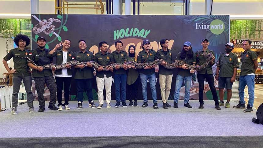 Komunitas Retic Pekanbaru memegang ular berukuran besar dalam salah satu iven di Pekanbaru.