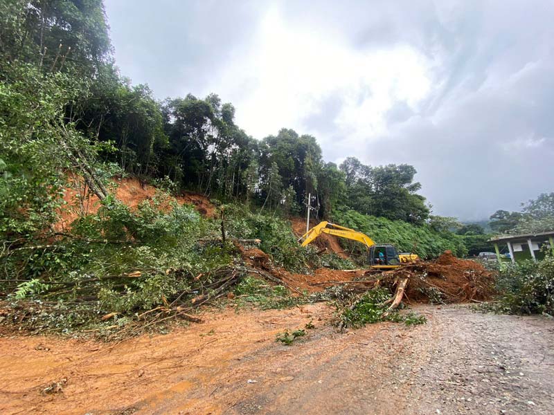 Petugas gabungan menggunakan alat berat untuk membersihkan material longsor di KM 35 jalan Sumbar-Riau, Ulu Aie, Kabupaten Limapuluh Kota, Sumatera Barat, Selasa (26/12/2023). Foto tengah, tim gabungan memindahkan batang pohon yang menghalangi jalan. Foto