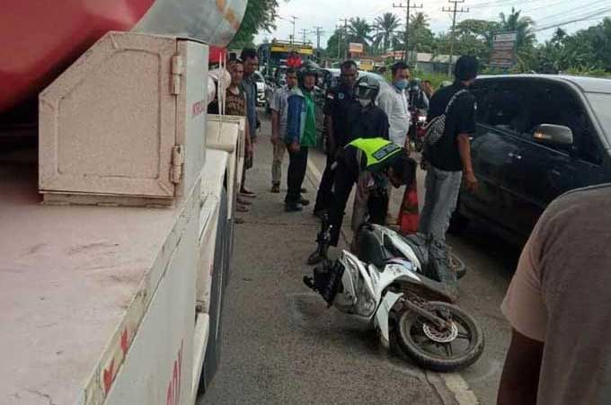 Petugas kepolisian dengan dibantu warga mengevakuasi sepeda motor yang terlibat tabrakan maut di Jalan Soekarno Hatta, Dumai, Senin (27/12/2021) petang.