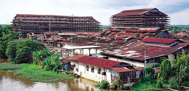 TUTUP: Atap bangunan pabrik karet PT Ricry yang mulai rusak, Kamis (24/1/2019). Pabrik di pinggir Sungai Siak, Jalan Yos Sudarso, Kecamatan Rumbai ini sudah berhenti beroperasi sejak delapan bulan lalu dan isi pabrik banyak dijarah.