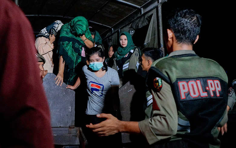 TERJARING: Sejumlah wanita turun dari truk saat tiba di Kantor Satpol PP Pekanbaru untuk dilakukan pendataan karena terjaring razia, Rabu (22/5/2019) dini hari. Sebanyak 58 orang terjaring razia yang dilakukan Satpol PP Pekanbaru di hotel dan penginapan.