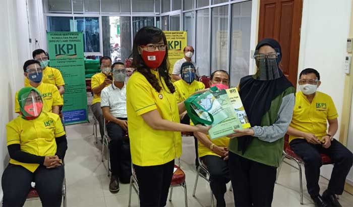 Ketua Ikatan Konsultan Pajak Indonesia (IKPI) Pekanbaru, Lilisen Chen saat menyerahkan buku UU, buku modul, face shield dan alat tulis oleh Ketua IKPI Pekanbaru kepada perwakilan peserta kursus brevet.(PANJI A SYUHADA/RIAUPOS.CO)