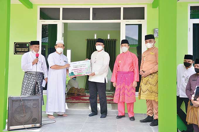 Direktur Utama Bank Riau Kepri Andi Buchari (tengah) disaksikan Gubernur Riau Syamsuar (dua kanan) menyerahkan pemakaian rumah imam masjid kepada Ketua Yayasan Nurul Iman Al Islam Riau Bintal Amin disaksikan Gubernur Riau Syamsuar, Jumat (17/12/2021).