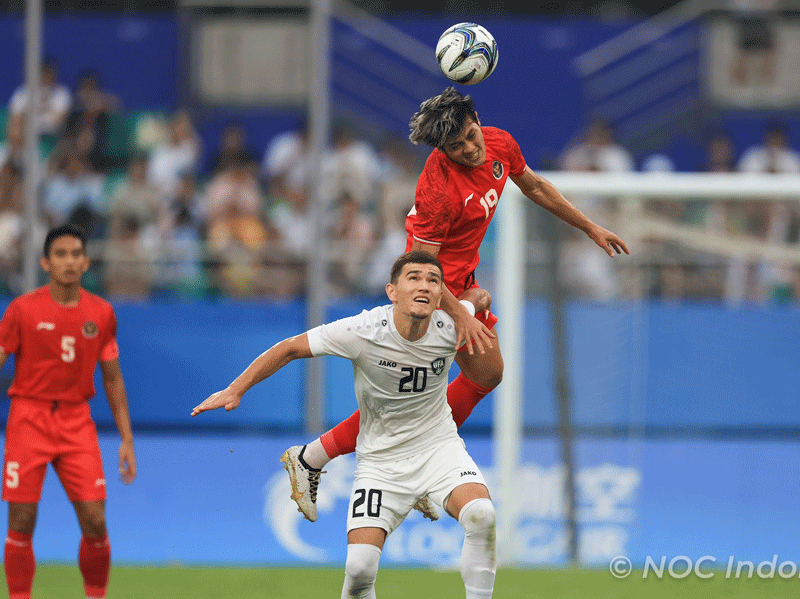 Pemain Indonesia Dewangga berduel di udara dengan pemain Uzbekistan dalam laga Babak 16 Besar Asian Games 2022 di Shangcheng Sports Centre Stadium, Hangzhou, Kamis (28/9/2023). Di laga ini Indonesia kalah 0-2 dan tersingkir.