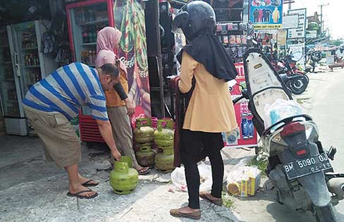 Membeli Gas: Seorang warga membeli elpiji 3 kg ke pedagang eceran di Jalan HR Soebrantas, Senin (22/10/2018) lalu. (CR2/MIRSHAL/RIAU POS)