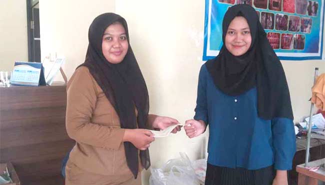SEDEKAH DARI SAMPAH:  Petugas Bank Sampah Bukit Hijau Berlian menyerahkan kwitansi bukti sampah yang disedekahkan oleh Fitri, warga Kecamatan Tampan, Selasa (9/10/2018). */mirshal/riau pos