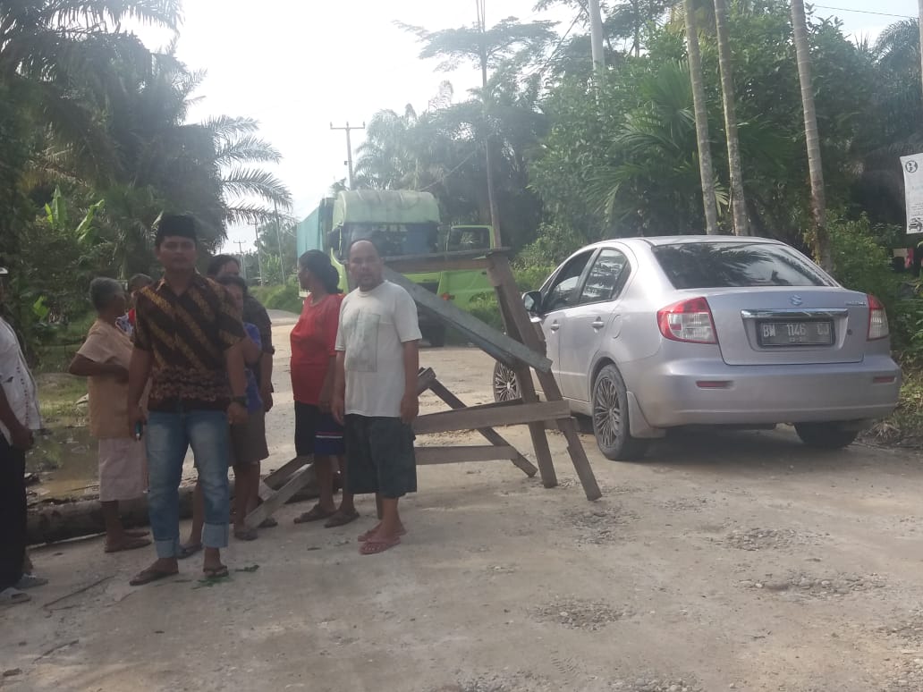 Warga simpang Asra PT KTU Kampung Pangkalan Pisang, Siak menutup akses jalan sebagai aksi demo menuntut pengaspalan jalan, Senin (27/1/2020).(Foto: WARGA SIAK FOR RIAUPOS.CO)