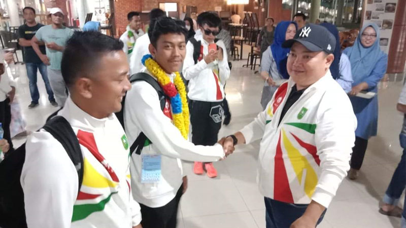 Kepala Bidang Pembudayaan Prestasi Olahraga Rinov Eka Mondrie (kanan) menyambut kepulangan kontingen Popnas Riau gelombang terakhir di Bandara SSK II, Pekanbaru, Selasa (5/9/2023).