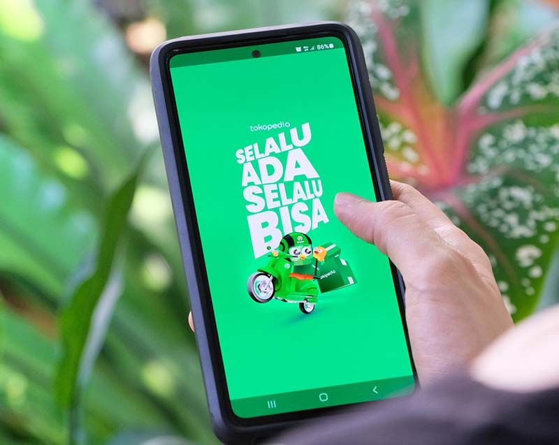 Warga memanfaatkan aplikasi Tokopedia untuk berbelanja online.