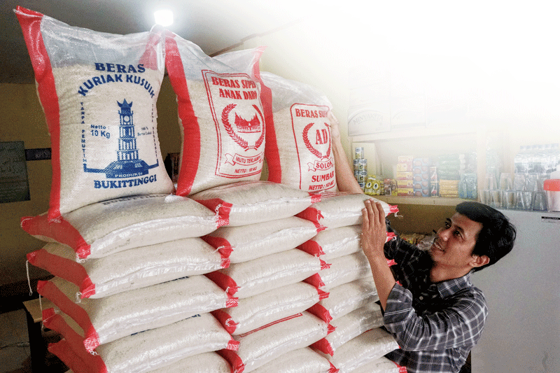 Seorang pedagang beras di Jalan Kertama, Pekanbaru, menyusun beras kemasan 10 kg yang dijual di kios miliknya, Selasa (12/9/2023).