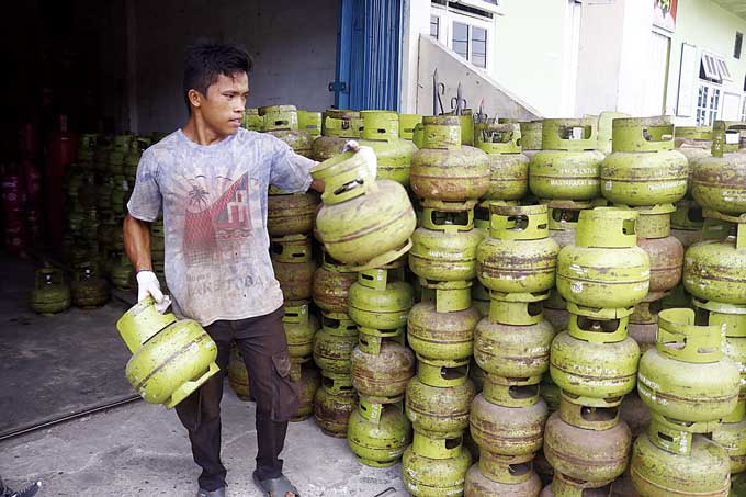 Pekerja mengangkat tabung elpiji 3 kg di pangkalan gas Jalan Kutilang, Kecamatan Sukajadi, Pekanbaru, baru-baru ini.