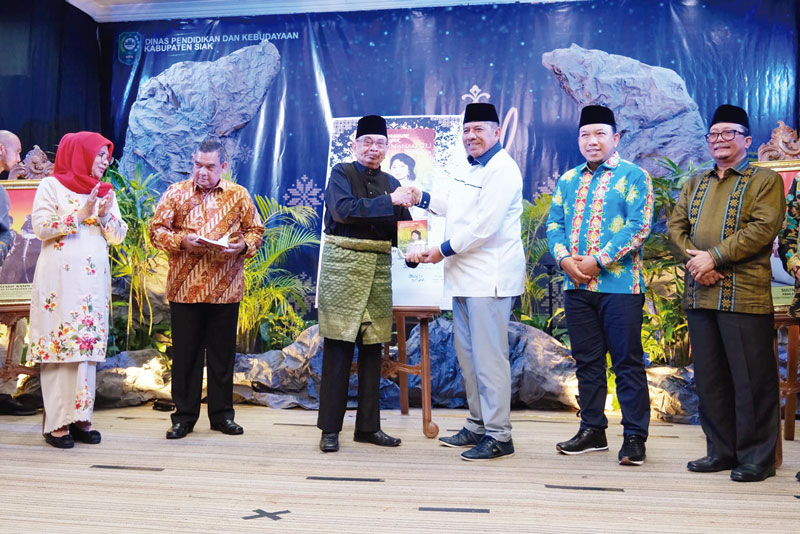 Bupati Siak Alfedri menerima buku dari Datuk OK Nizami Jamil (tiga kiri) saat peluncuran buku Kisah Permaisuri Kerajaan Siak Tengku Maharatu di Gedung Tengku Mahratu, Kota Siak Sri Indrapura, Ahad (15/10/2023).