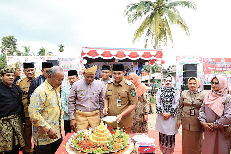 Wakil Bupati Rohul H Indra Gunawan menyerahkan potongan nasi tumpeng kepada Kades Sungai Kuning, Kecamatan Rambah Samo Abdul Halik, saat menghadiri peringatan HUT ke-16 Desa Sungai Kuning, Selasa (22/8/2023).