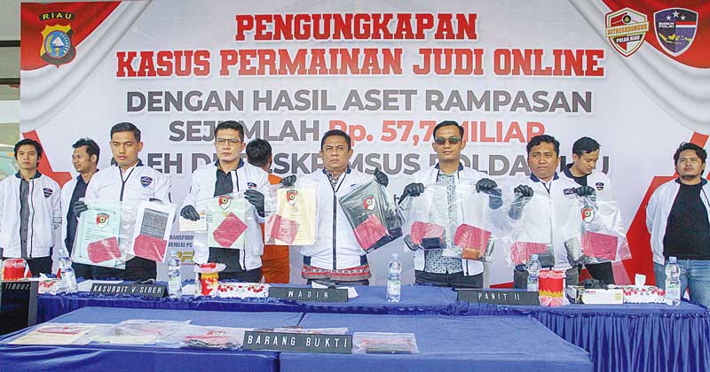 Wadirkrimsus Polda Riau AKBP Iwan P Manurung (tengah) memperlihatkan barang bukti dalam ekspose penangkapan afiliator judi online di Pekanbaru berinisial AG didampingi Kasubdit V Kompol Fajri (dua kiri) dan Panit II Subdit V Ipda Ipda Nelfian Zulbairi (du