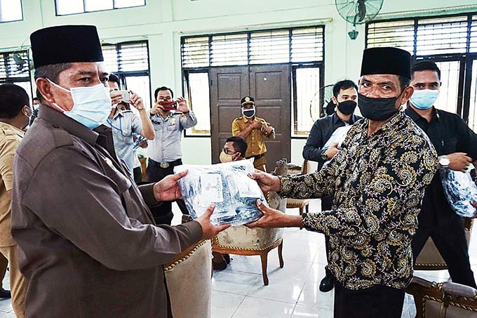 Bupati Siak H Alfedri membagikan masker kepada pengurus tempat ibadah di aula Kantor Camat Pusako, Selasa (24/8/2021).