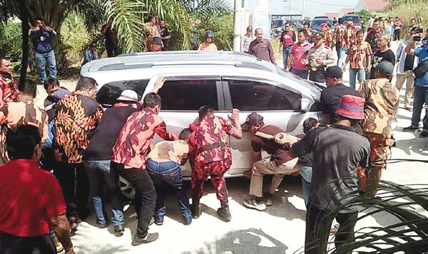 DIPINDAHKAN: Mobil warga yang dibelintangkan di jalan untuk memprotes peresmian Water Park Harationica di Duri, dipindahkan panitia ke pinggir jalan, Sabtu (25/8/2018). (SYUKRI DATASAN/RIAU POS)