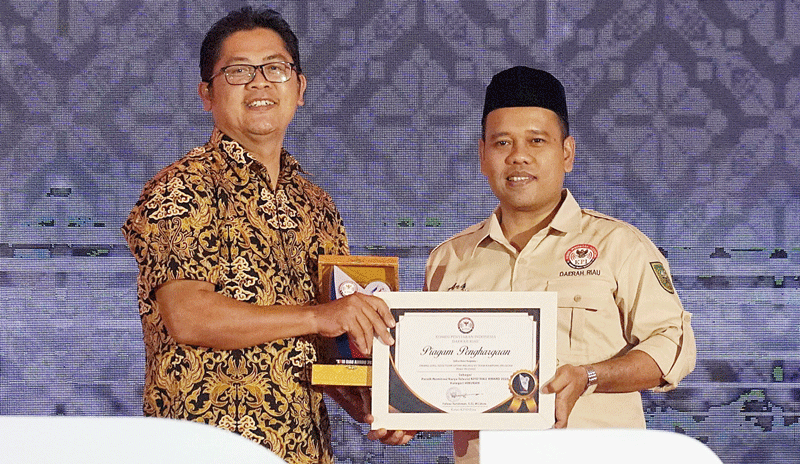 Direktur Utama Riau Televisi Ahmad Dardiri (kiri) menerima penghargaan KPID Riau Award 2023 dari Korbid PIS KPID Riau Ahmad Rayhan Qodri di Gedung Daerah Provinsi Riau, Ahad (20/8/2023).