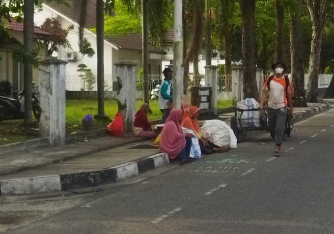 Sejumlah pengemis sambil membawa karung putih duduk di pinggir trotoar Jalan Dipenogoro, Senin (17/4/2023).