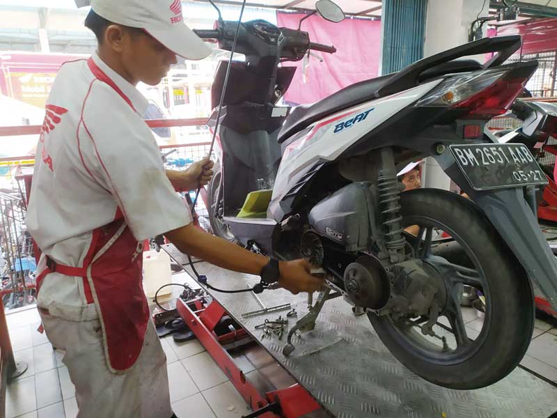 Mekanik AHASS sedang mengecek motor Honda matic pelanggan, baru-baru ini.
